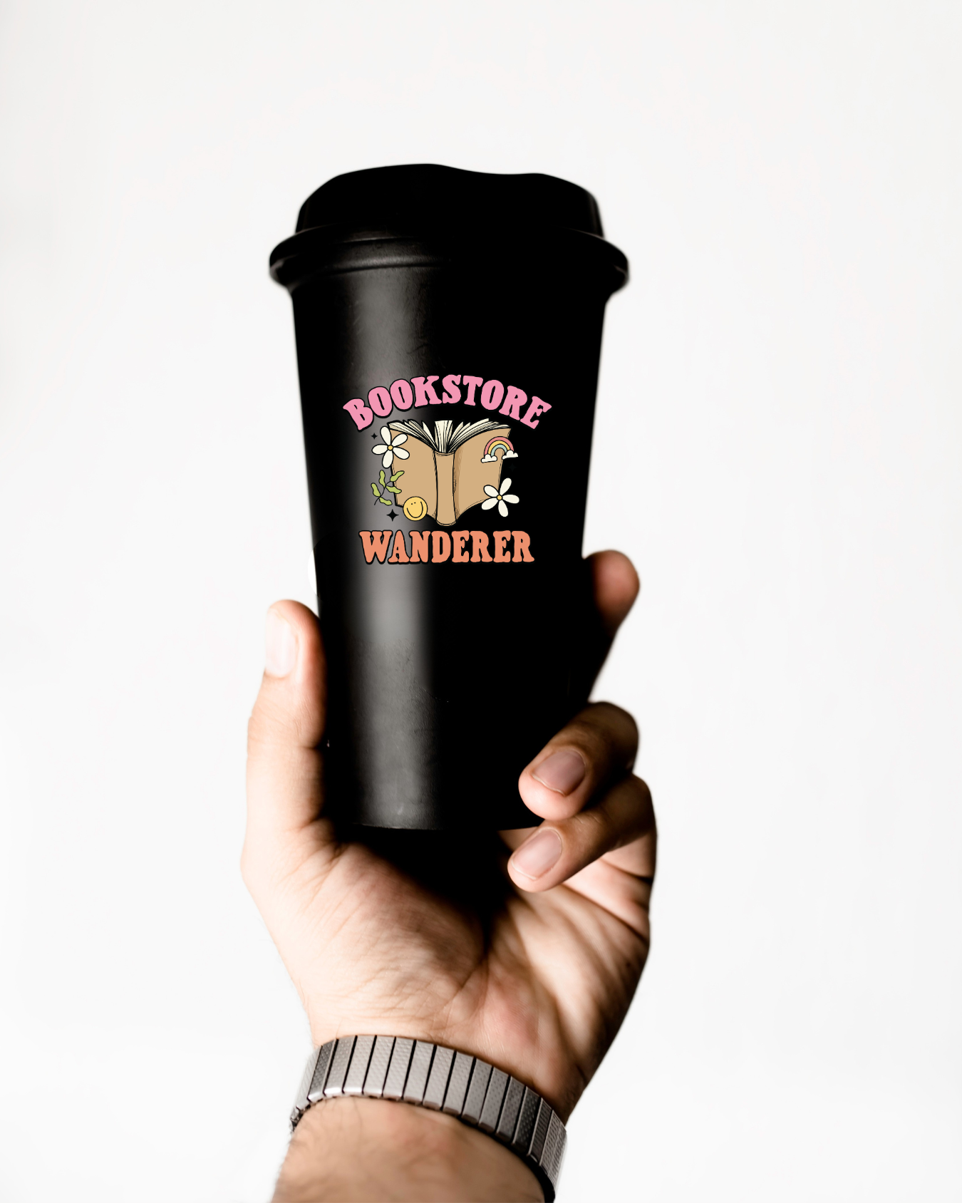 Black travel mug with 'Bookstore Wanderer' design held by a hand on a white background