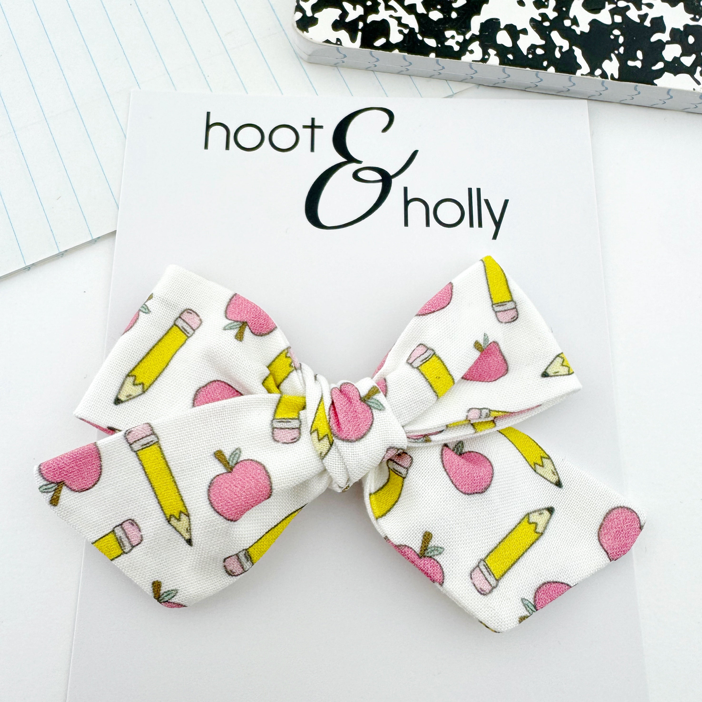 Hand-tied hair bow with apples and pencils.