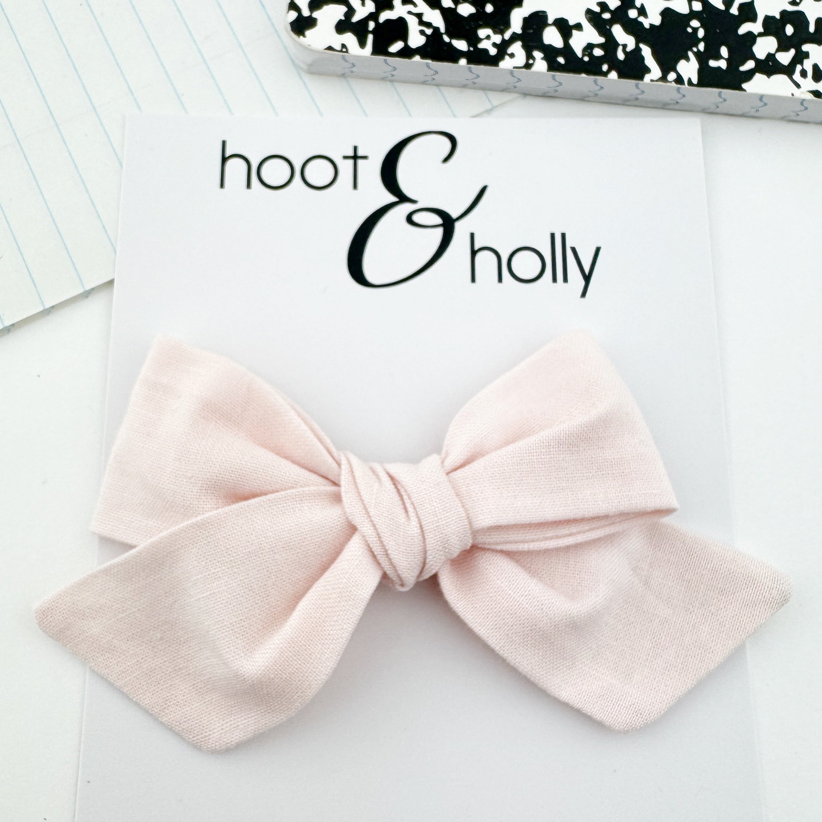 Hand-tied pale pink hair bow.
