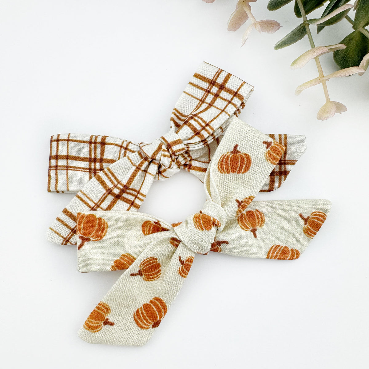A pumpkin-patterned cotton hair bow and a plaid cotton hand tied bow for girls