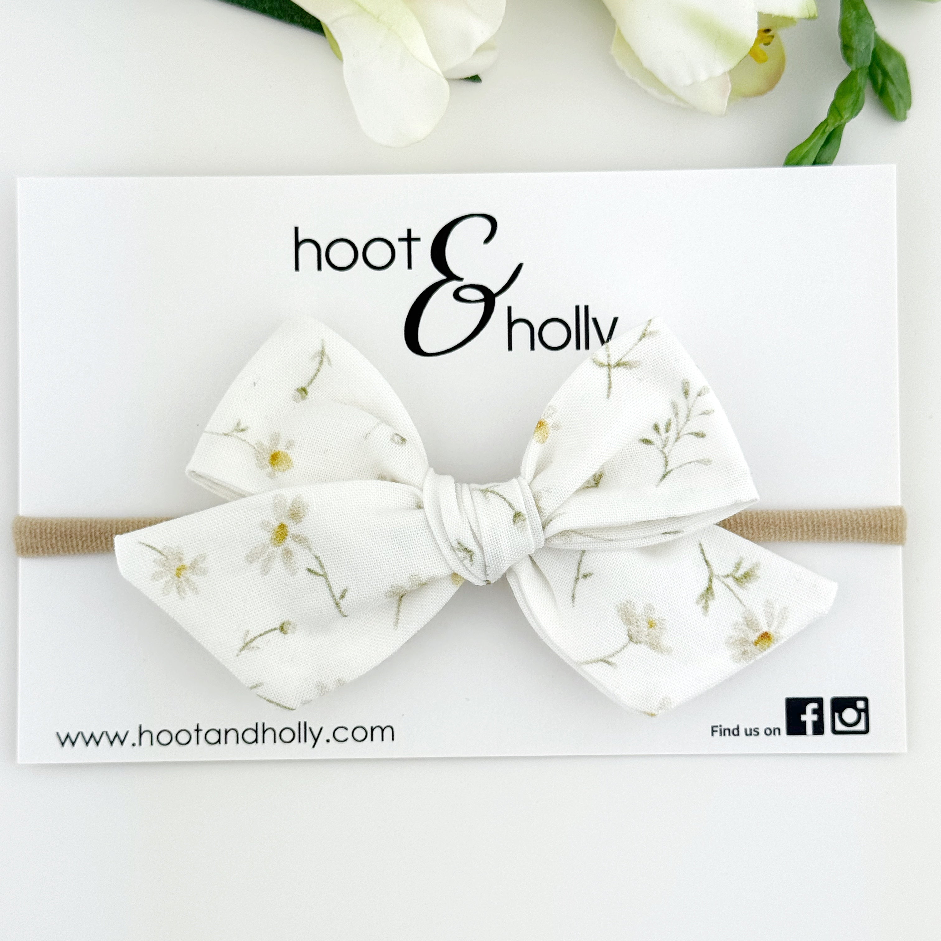 Floral bow headband on a white card with 'hoot & holly' branding