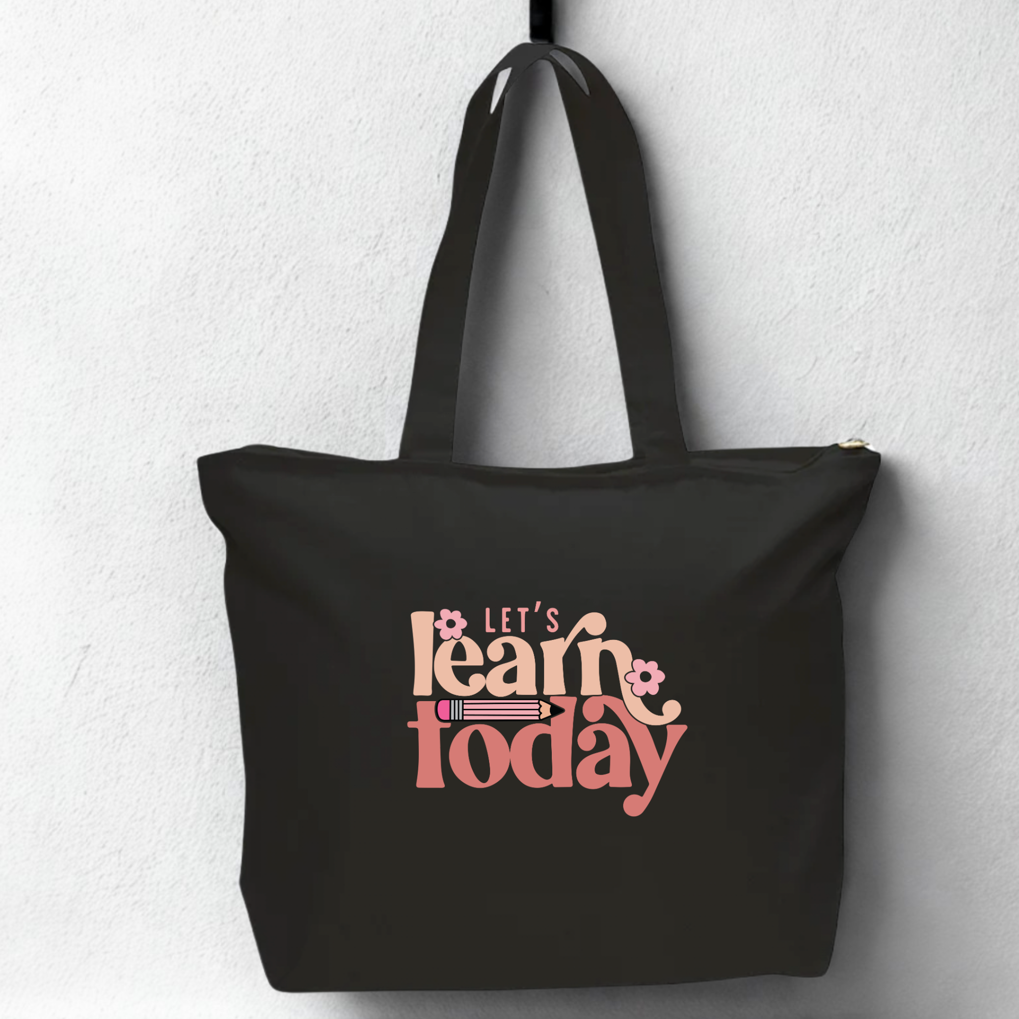 Black tote bag with 'Let's Learn Today' text on a light gray background