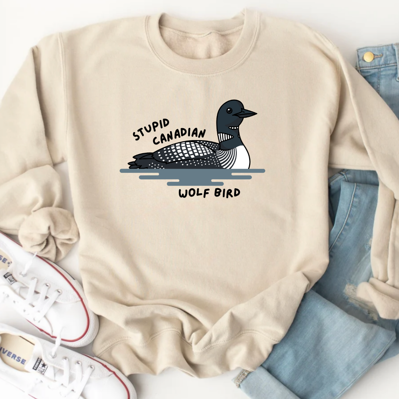 Beige sweatshirt with a graphic of a bird and text, displayed with jeans and sneakers.